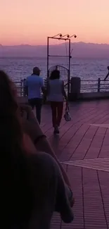 Couple walking along the seaside at sunset.