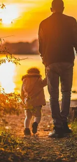 Parent and child walking at sunset along a lakeside path.