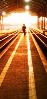 Silhouette at sunset on train tracks with warm orange glow.