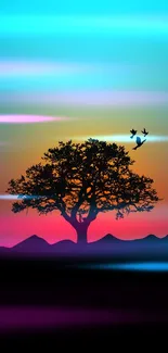 Sunset tree silhouette with birds and colorful gradient sky.