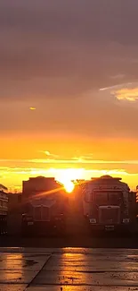 Trucks parked under a vibrant orange sunset sky.