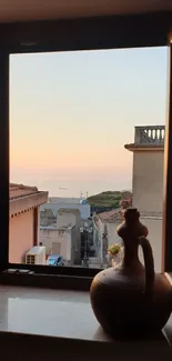 Sunset view through a rustic window overlooking a coastal town.