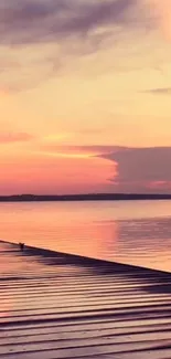 A calming sunset over a tranquil lake with pink and orange reflections.