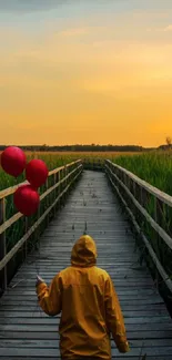 A person walks on a wooden path at sunset holding red balloons.