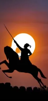 Silhouetted warrior on horse against sunset sky.