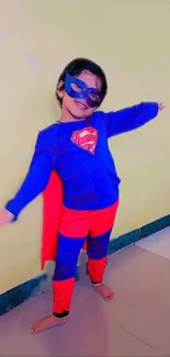 Child in colorful superhero costume standing with open arms.