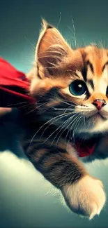 Adorable kitten with a red cape flying like a superhero in a teal background.