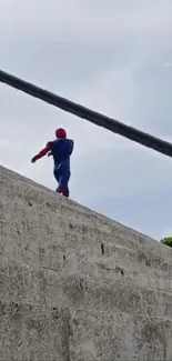 Superhero ascending a concrete stairway under a bright sky.