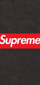 Supreme logo on black textured background wallpaper.