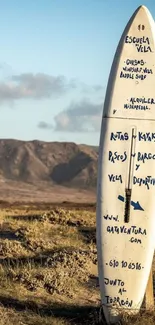 Surfboard standing alone in desert landscape under blue sky.