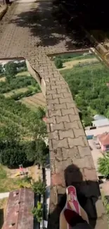 Surreal brick path over lush village landscape.