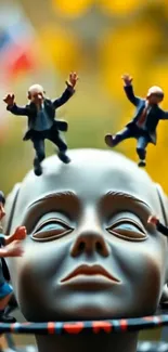Surreal sculpture with dancing figurines on mobile wallpaper.