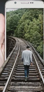 Surreal phone with train tracks and person image.