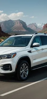 White SUV in a stunning desert landscape with mountains.