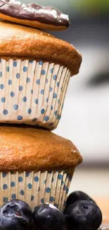 Stacked blueberry cupcakes with chocolate topping.