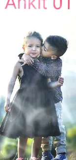 Two children embracing on a scenic green hillside at daytime.