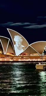 Sydney Opera House illuminated at night over water.