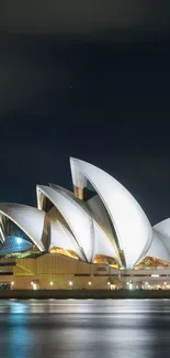 Sydney Opera House at night reflecting on water.