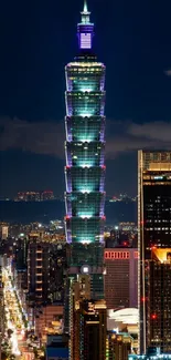 Taipei 101 tower illuminated against a dark night sky with city lights below.