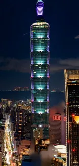 Night view of Taipei 101 tower illuminated against city skyline.