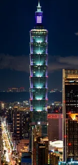 Night view of Taipei 101 towering over city lights.