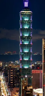 Taipei 101 tower glowing at night, surrounded by city lights.