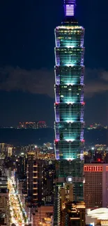 Illuminated Taipei 101 at night with the city skyline in view.