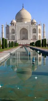 Taj Mahal reflected in serene water with a clear blue sky backdrop.