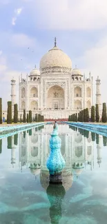 Taj Mahal reflected in blue waters with sky backdrop.