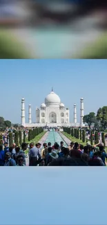 Taj Mahal with tourists under a blue sky.