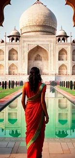 Woman in sari gazing at the Taj Mahal reflection