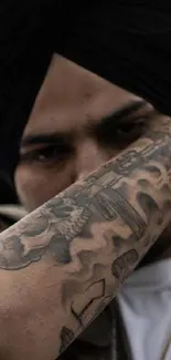 Close-up of tattooed arm and silver bracelet.