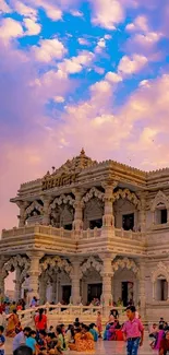 Ornate temple with people under vibrant sky.