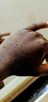 Close-up of a textured hand with water droplets on skin.