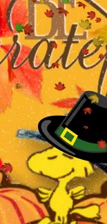 Snoopy in a Thanksgiving hat with pumpkins and autumn leaves.