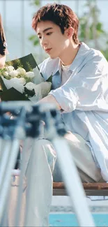 Serene person sitting with flowers on a bench.