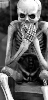 Monochrome skeletons embodying 'see, hear, speak no evil' art.