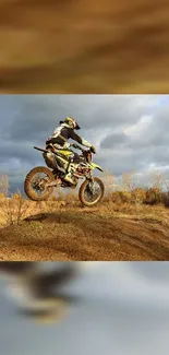 Motocross rider jumps on dirt bike against a cloudy sky.