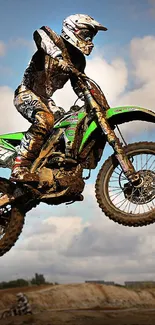 Dirt bike in mid-air against a cloudy sky, showcasing extreme off-road action.