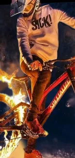 Biker engulfed in fire doing a daring stunt on a fiery cycle at night.