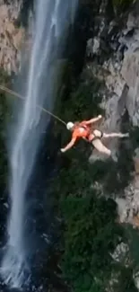 Person cliff jumping by a waterfall in a stunning natural scene.