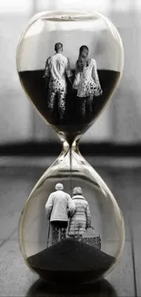 Hourglass with reflections of young and old couples on a wooden floor.