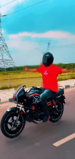 Biker in red shirt riding on open road with clear sky overhead.