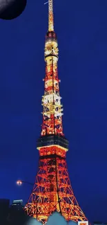 Tokyo Tower beautifully illuminated at night under a deep blue sky.