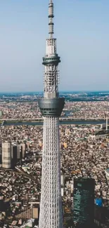 Tokyo tower against a clear blue sky, city below.