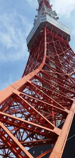 Striking red Tokyo Tower against blue sky.