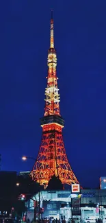 Tokyo Tower illuminated at night, glowing against the deep blue sky.