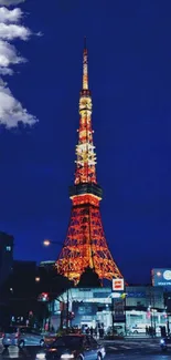 Illuminated Tokyo Tower at night with bustling city traffic.