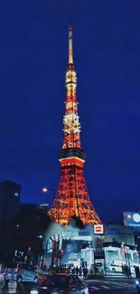 Tokyo Tower glowing at night in vibrant orange hues against a dark blue sky.