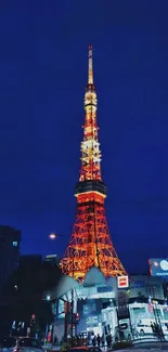 Tokyo Tower illuminated against a dark blue night sky.